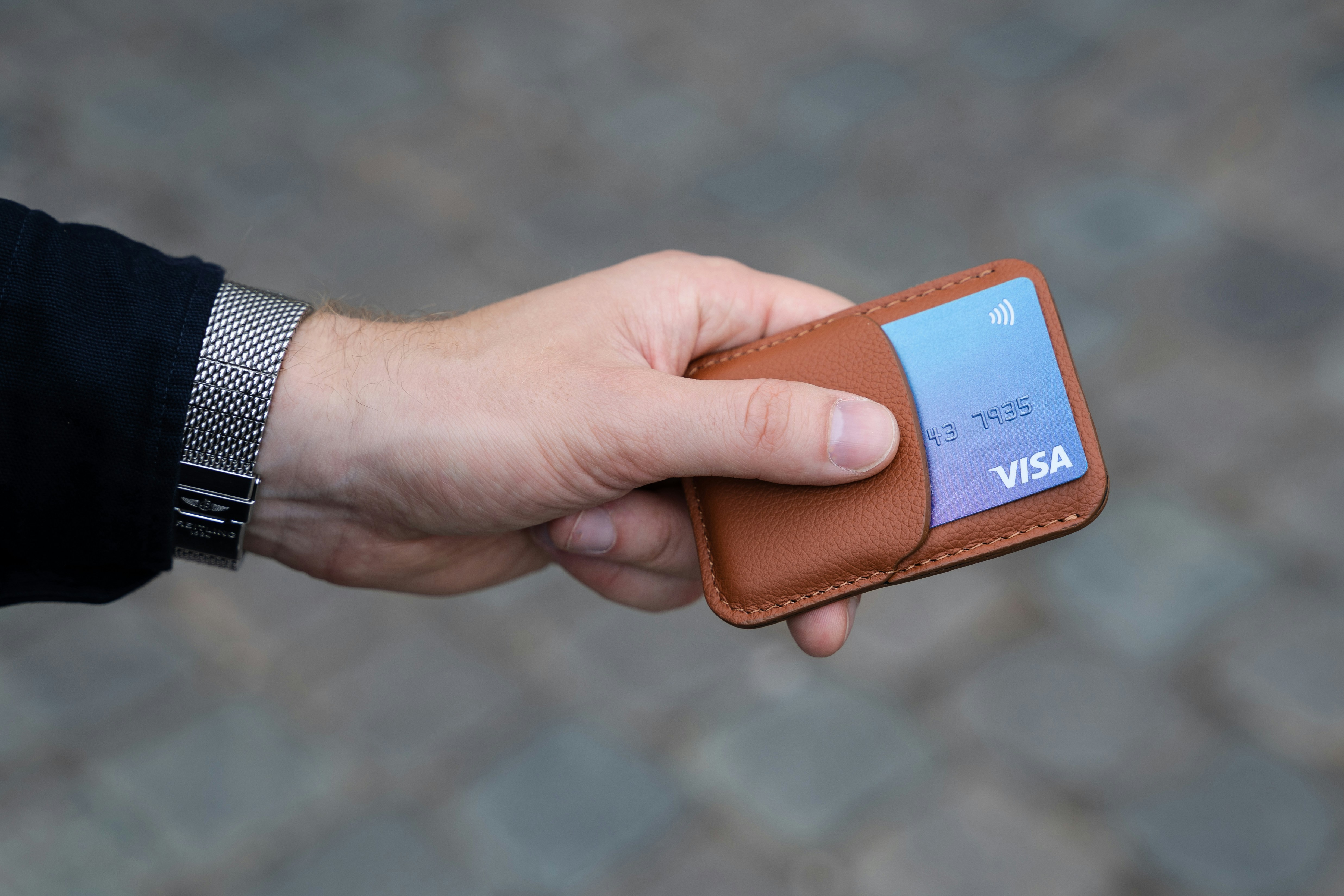 Man holding a Visa Card in a card wallet of some kind.